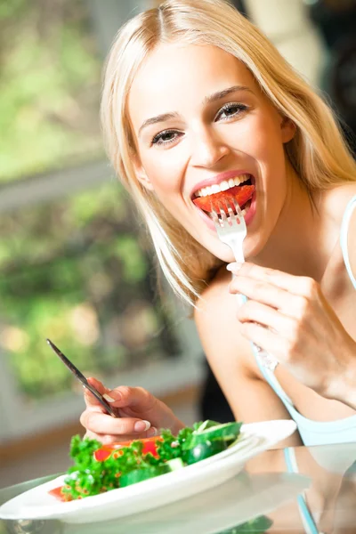 Молодая счастливая улыбающаяся женщина ест вегетарианский салат — стоковое фото