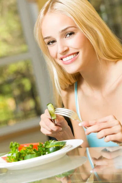 Jovem feliz sorrindo mulher comendo salada em casa — Fotografia de Stock