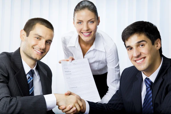 Tre företagare handskakning med dokument på kontor — Stockfoto