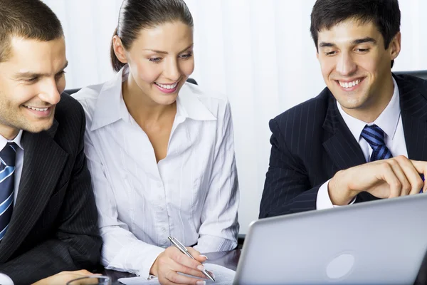 Drie zakenmensen werken met laptop op kantoor — Stockfoto