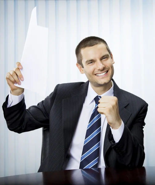 Glad framgångsrik gestikulerande affärsman med dokument på kontor — Stockfoto