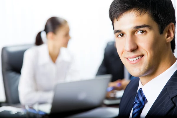 Businessman and colleagues on background, at office — Stock Photo, Image