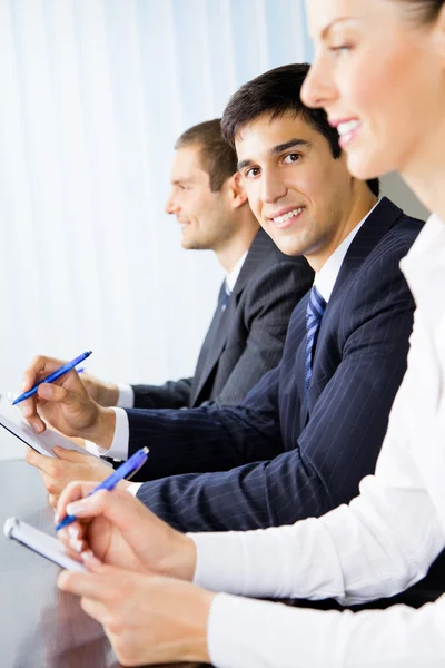 Tre glada leende företagare på mötet, presentation eller c — Stockfoto