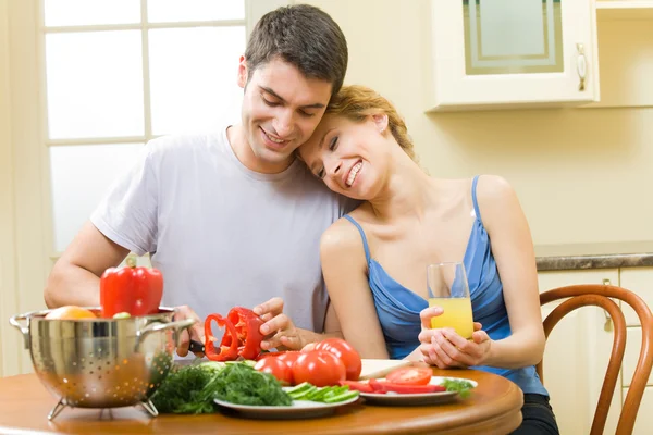 Молодая счастливая пара делает салат дома вместе — стоковое фото