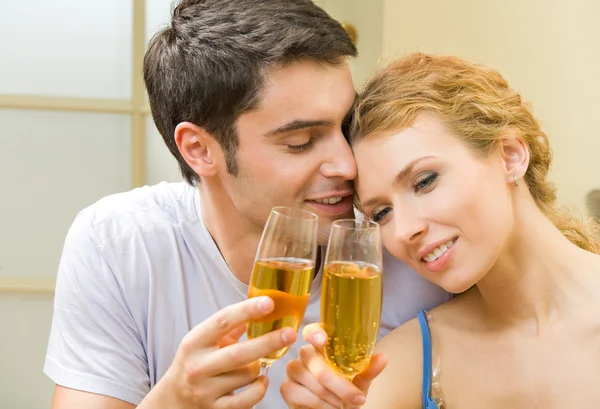 Ungt par firar med champagne hemma — Stockfoto