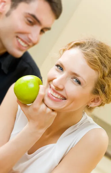 Retrato de jovem casal amoroso com maçã em casa — Fotografia de Stock
