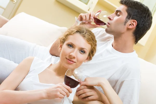Pareja joven celebrando con vino tinto en casa —  Fotos de Stock