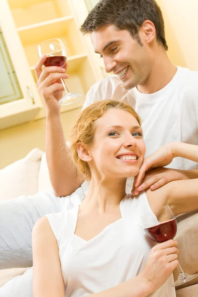 Młoda para obchodzi z czerwonego wina w domu — Zdjęcie stockowe