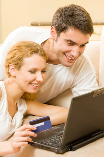 Junges glückliches Paar bezahlt mit Kreditkarte im Internet-Shop — Stockfoto