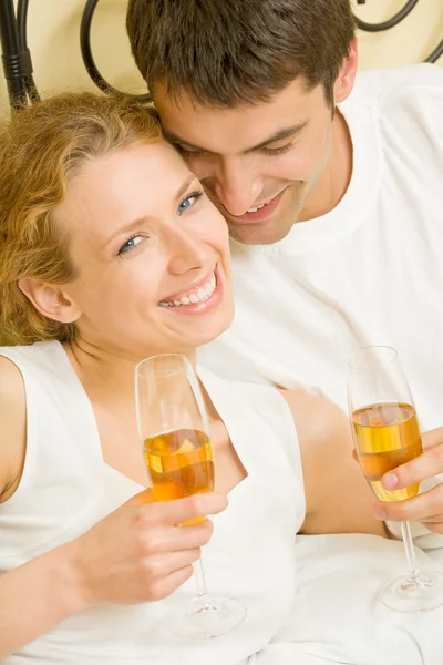 Ungt par firar med champagne på sovrum — Stockfoto