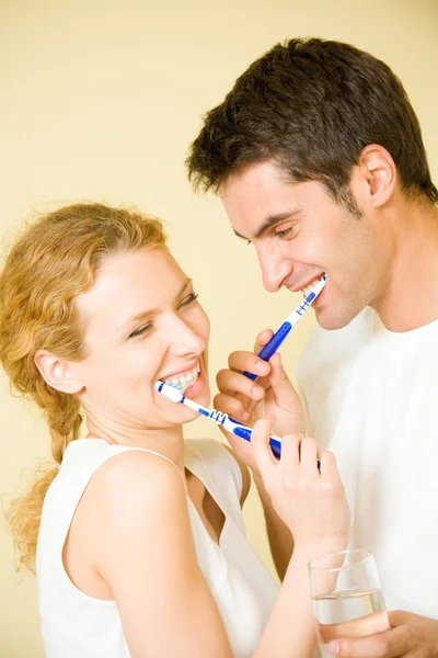 Jovem casal de limpeza de dentes juntos no banheiro — Fotografia de Stock