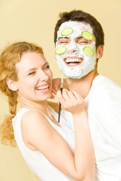Joven feliz alegre pareja haciendo mascarilla facial en casa — Foto de Stock