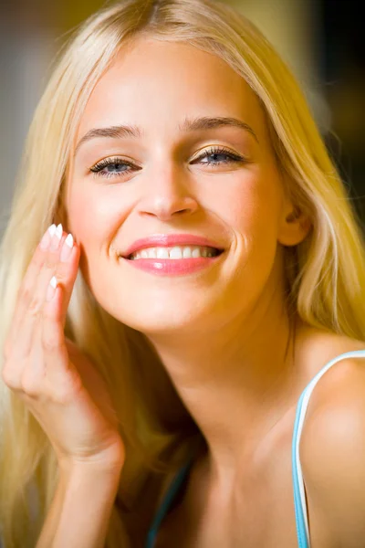 Retrato de una joven hermosa mujer aplicando crema — Foto de Stock