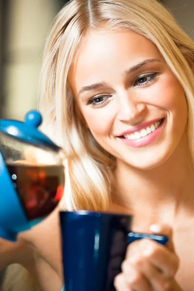 Retrato de jovem feliz sorrindo mulher com bule e xícara, indoo — Fotografia de Stock