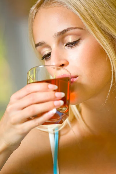 Portrait of young beautiful woman with glass of juice, indoors — Stock Photo, Image