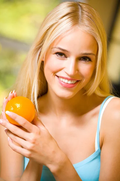 Portrét mladé šťastná usmívající se žena s pomerančem — Stock fotografie