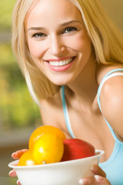 Portrait of young happy smiling woman with plate of fruits — Stock Photo, Image
