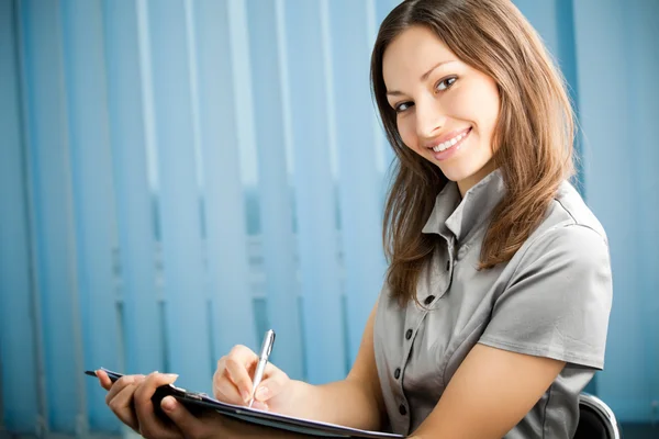 Portrait of writing happy smiling businesswoman working at offic — Stock Photo, Image