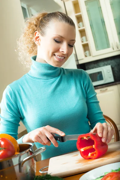 Porträtt av glada leende kvinna matlagning med grönsaker, hemma — Stockfoto
