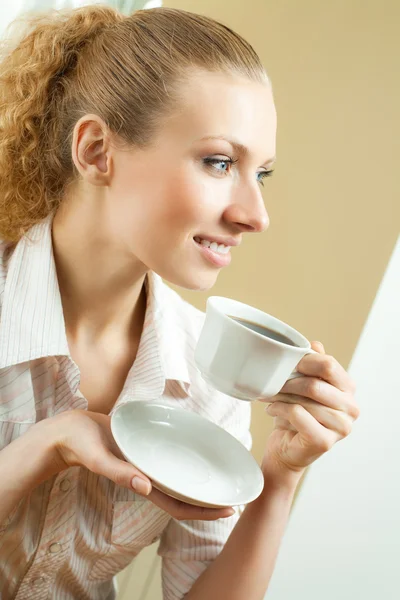 Young smiling woman drinking coffee, at home — Stock Photo, Image