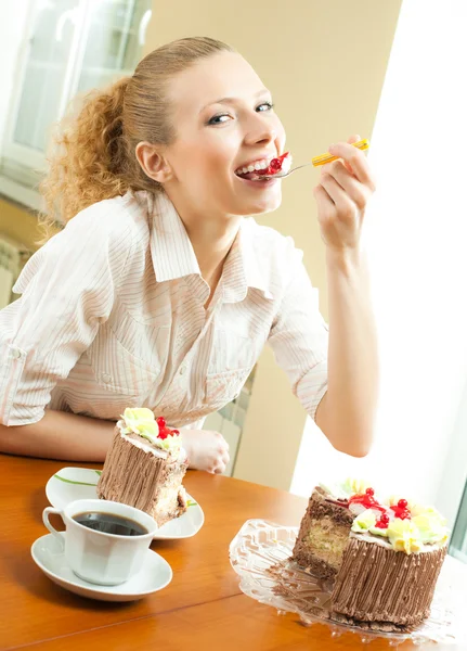 Νεαρή γυναίκα τρώει torte στο σπίτι — Φωτογραφία Αρχείου