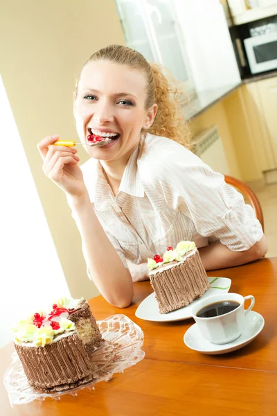 年轻快乐微笑美丽的年轻女子在家里吃蛋糕 — 图库照片