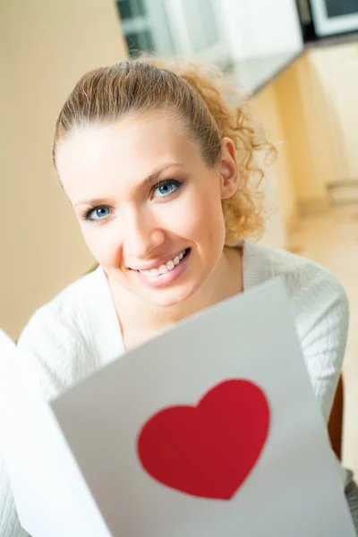 Mladá šťastná usmívající se krásná žena, čtení valentine karty doma — Stock fotografie