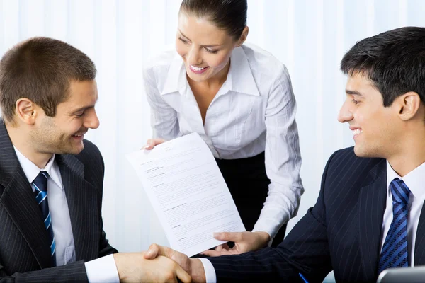 Empresários aperto de mão com documento no escritório — Fotografia de Stock