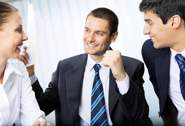 Szczęśliwy biznesmen z dokumentu i współpracowników w biurze — Zdjęcie stockowe
