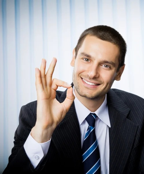 Empresario con signo de mano bien en la oficina —  Fotos de Stock