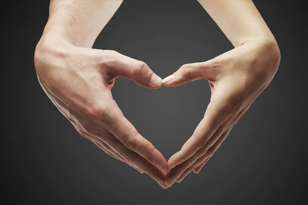Forma de corazón hecha de manos femeninas y masculinas juntas — Foto de Stock