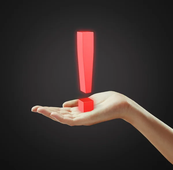 Ponto de exclamação vermelho na mão de uma mulher — Fotografia de Stock