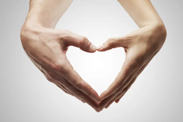 Forma de coração feito de mãos femininas e masculinas juntas — Fotografia de Stock