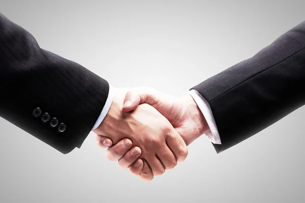 Handshake - ruka drží na šedém pozadí — Stock fotografie