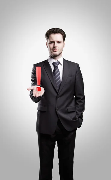 Young businessman with an exclamation mark on his hand — Stock Photo, Image