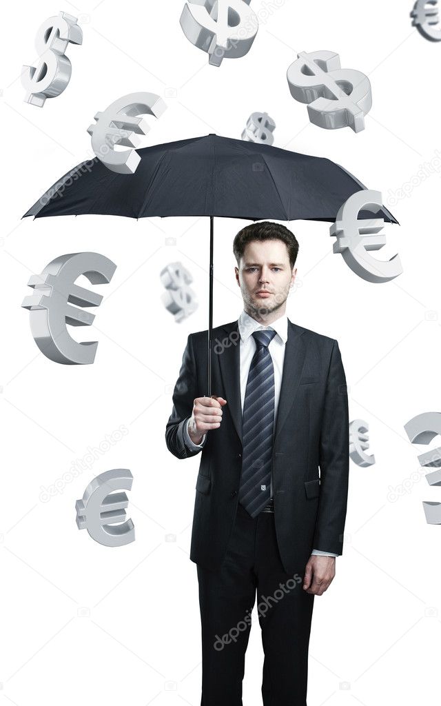 Business man with umbrella under evro and dollar signs rain