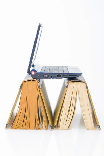Computadora portátil en libros — Foto de Stock