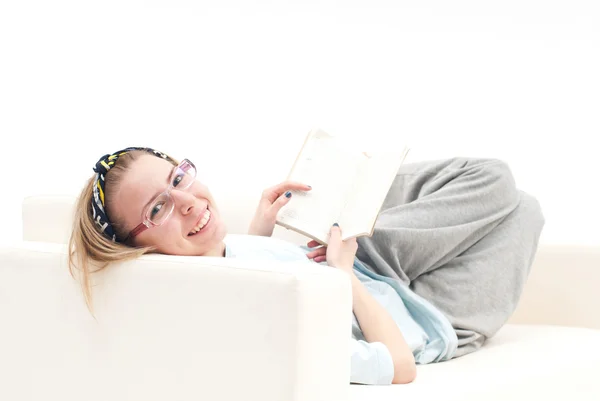 Pohodovou dívku, na pohovce, s úsměvem Stock Obrázky