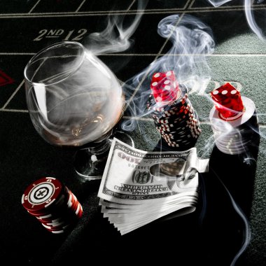 Dice, money, drink and chips on dice table at casino