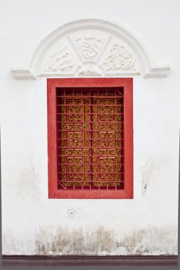 Thai tallada ventanas en la pared blanca