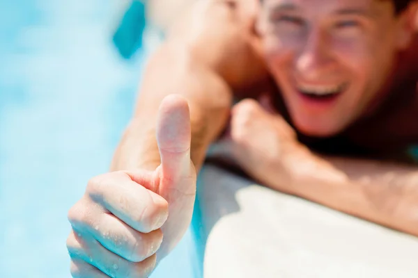 Человек, показывающий большие пальцы возле бассейна Лицензионные Стоковые Изображения