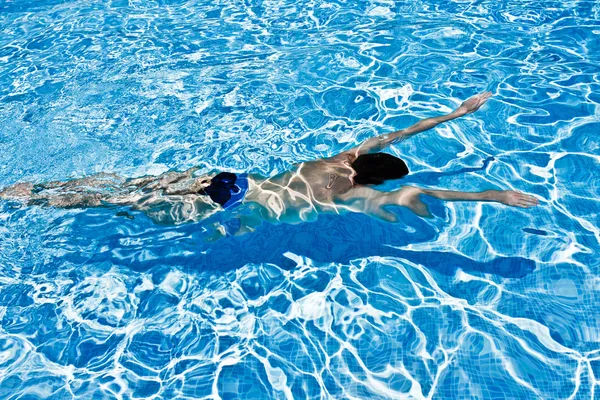 Homme nageant sous l'eau dans la piscine Image En Vente
