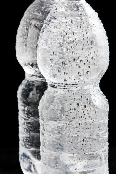 Пластиковые бутылки на черной поверхности — стоковое фото