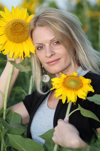 stock image Beauty woman and sunflowers on field