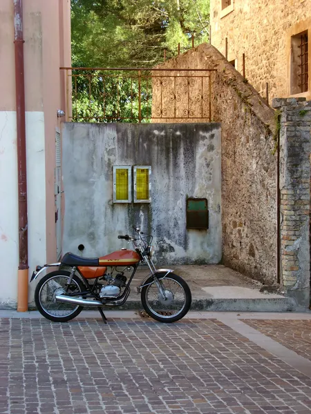 Régi olasz motorkerékpár feltoljuk kőfal — Stock Fotó