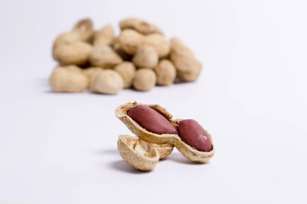 Goldene Erdnüsse auf weißem Hintergrund — Stockfoto