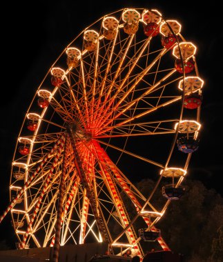 Illuminated ferris wheel at night clipart