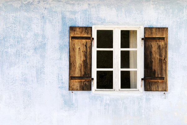Window on an old weathered blue wall