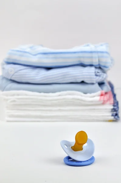 Pacifier and Blue Baby Clothes — Stock Photo, Image