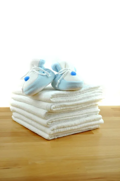 Blue Baby Shoes on Baby Clothes Stockbild